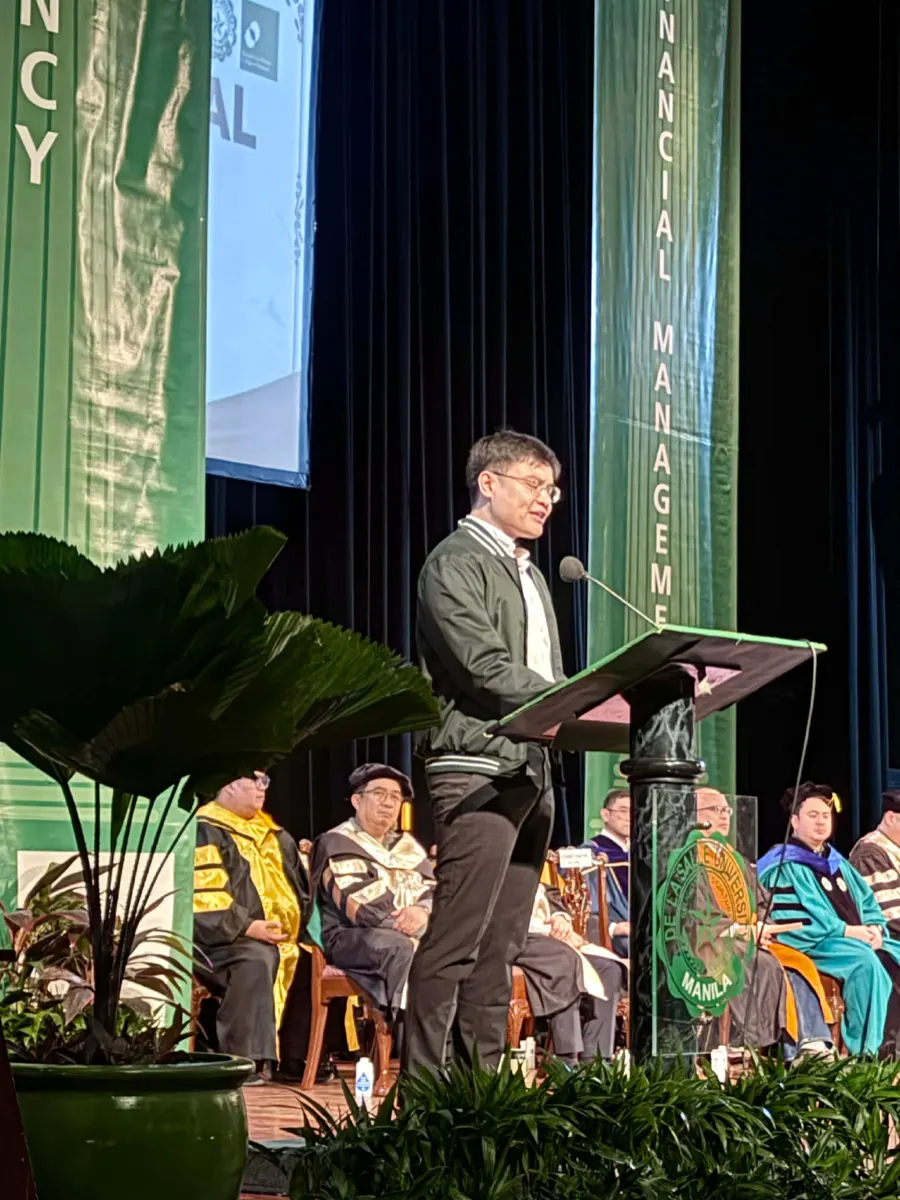 Edward P. Martinez speaking at a lectern at De La Salle University Manila
